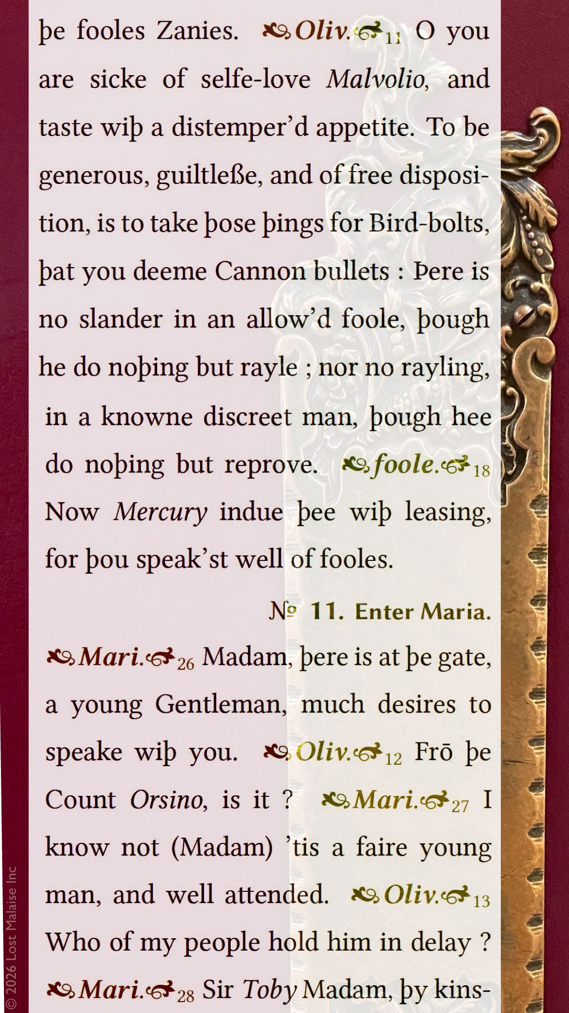 Shakespeare *Twelfth Night* text featuring Viola disguised as Cesario speaking with Valentine and Duke Orsino, overlaid on an ornate antique theater door at Cumston Hall in Monmouth, Maine, with decorative brass hardware and warm pink interior walls.
